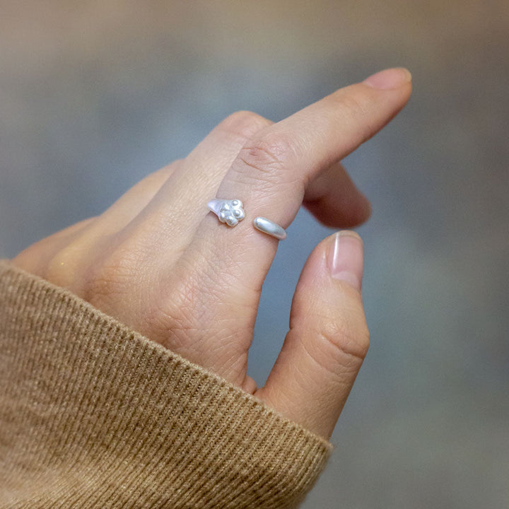 Sterling silver ring with cat paw design, accompanied by a greeting card in a gift box.