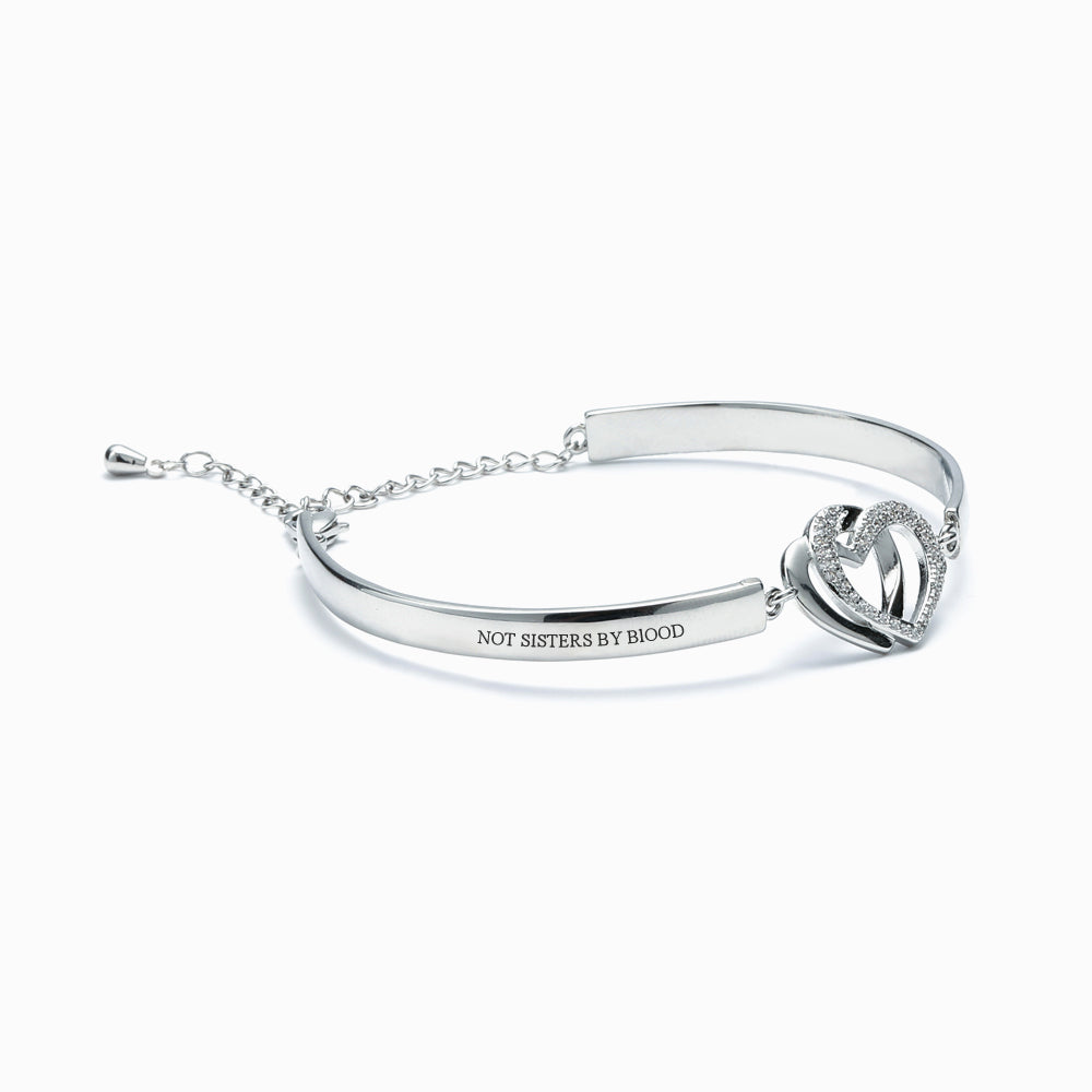 Double Heart Bracelet with intertwined rings, engraved with "Not sisters by blood but sisters by heart", symbolizing strong friendship bonds, made of copper with plating finish