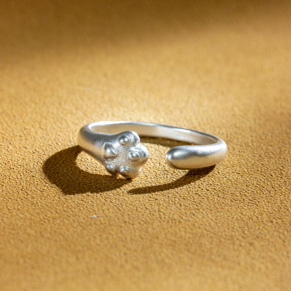 Sterling silver ring with cat paw design, accompanied by a greeting card in a gift box.