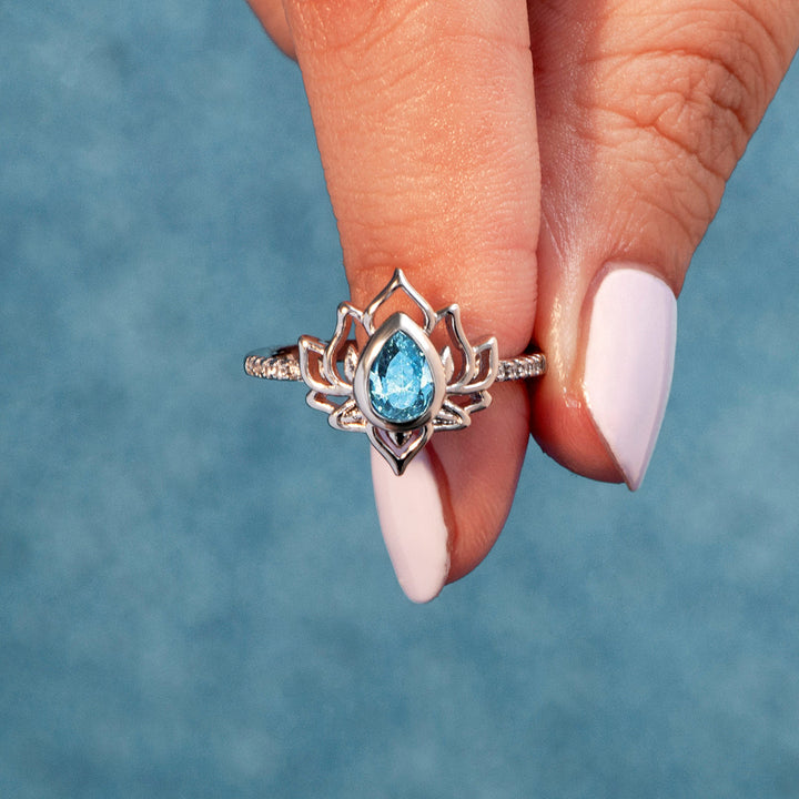 The image shows a silver ring with a lotus design, surrounded by a greeting card, a gift bouquet, a gift box, and a gift bag. The greeting card reads "GROW & BELIEVE Every day is a New Beginning take a deep breath and start again." The ring is part of the "Every day is a New Beginning" set, made of S925 sterling silver with a zircon stone. It is suitable for all ages.