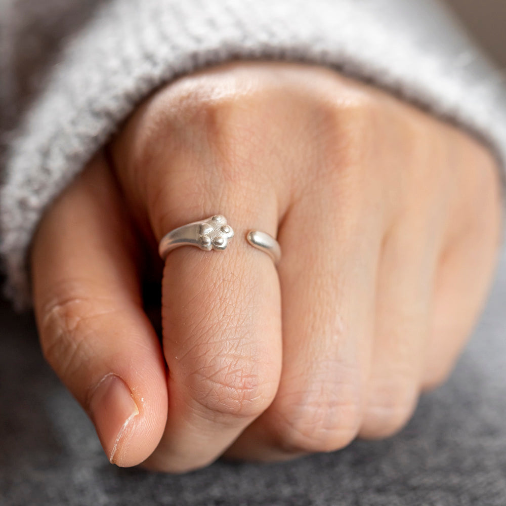 Sterling silver ring with cat paw design, accompanied by a greeting card in a gift box.