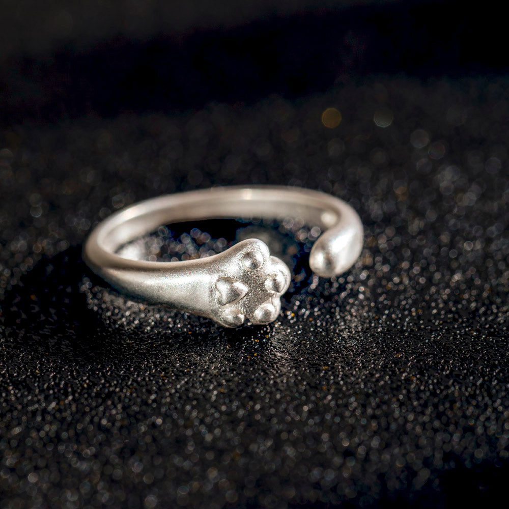 Sterling silver ring with cat paw design, accompanied by a greeting card in a gift box.