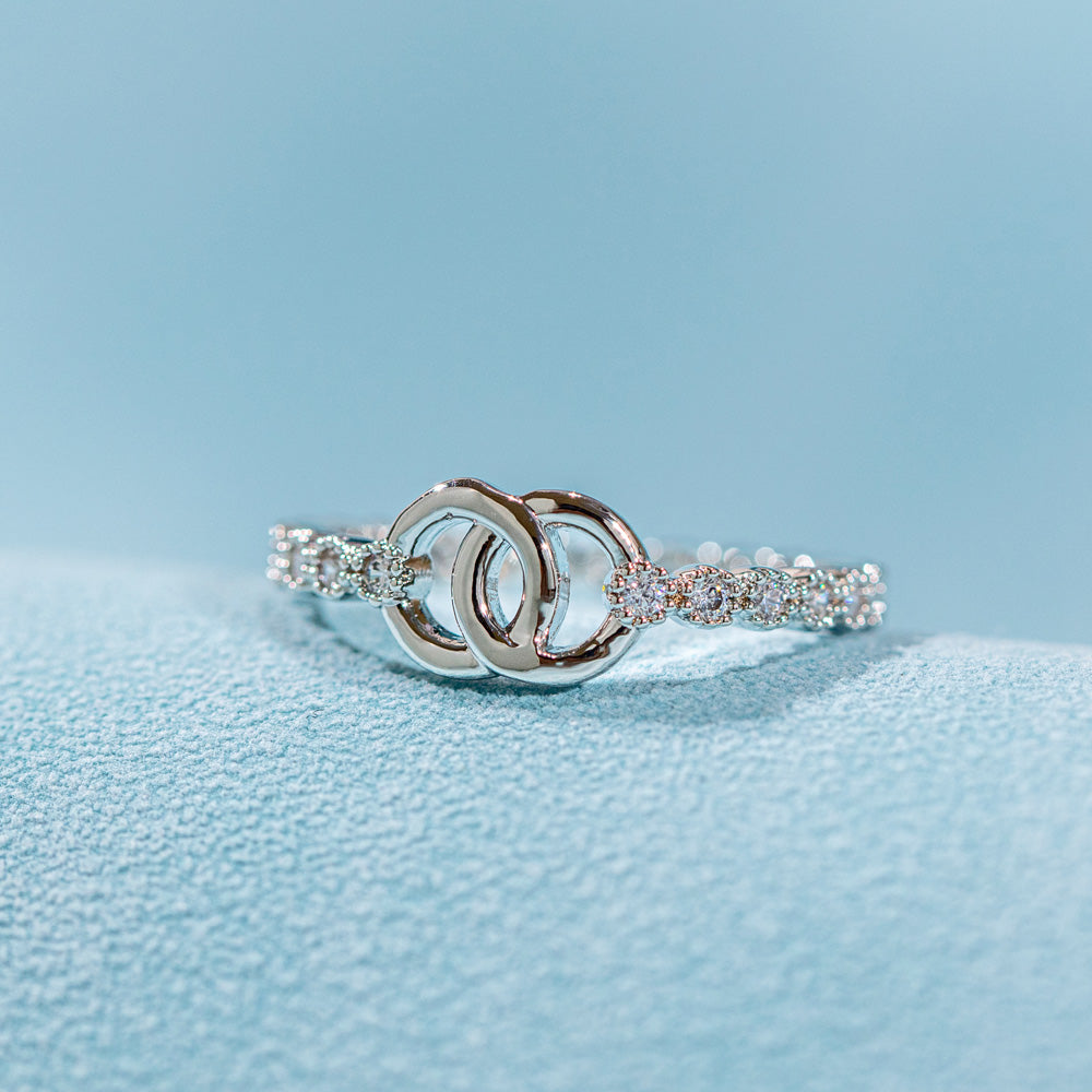 Pictured here is a single 'To My Daughter Forever linked' Interlocking Ring. This ring features two interlocking circular designs, symbolizing the unbreakable bond between mother and daughter. The set includes the ring, a greeting card, a gift box and a gift bag to hold it all. Material: S925 sterling silver, processing technique: plated.