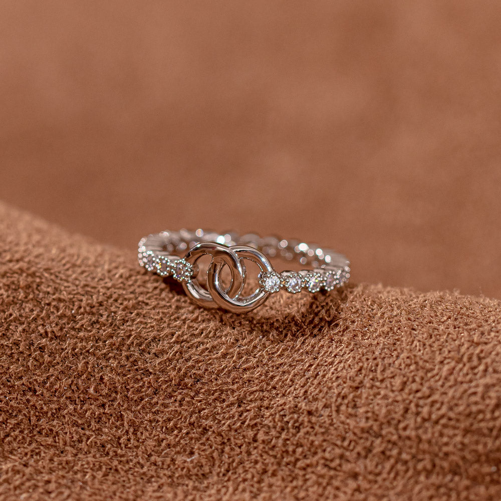 Pictured here is a single 'To My Daughter Forever linked' Interlocking Ring. This ring features two interlocking circular designs, symbolizing the unbreakable bond between mother and daughter. The set includes the ring, a greeting card, a gift box and a gift bag to hold it all. Material: S925 sterling silver, processing technique: plated.