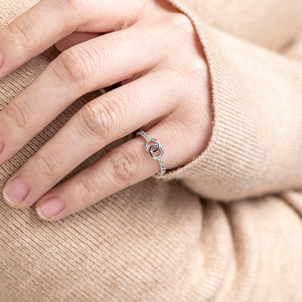 Pictured here is a single 'To My Daughter Forever linked' Interlocking Ring worn on the finger of a hand. This ring features two interlocking circular designs, symbolizing the unbreakable bond between mother and daughter.