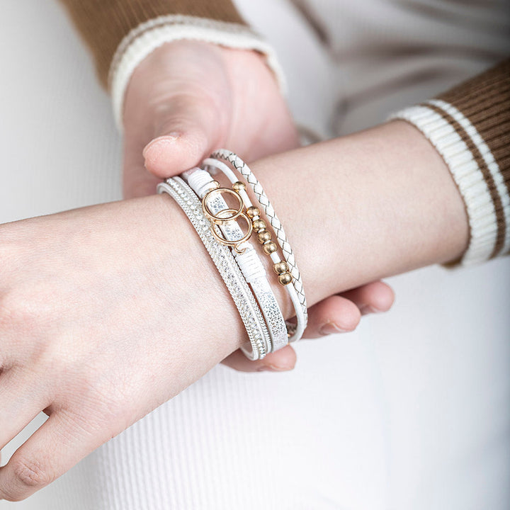 A close-up view of a leather bracelet with two interlocking rings at its center, representing the eternal bond between a granddaughter and a grandmother. The bracelet is accompanied by a greeting card and packaged in a gift box and bag. Material: Leather. Processing Techniques: Plating. Suitable for all ages."