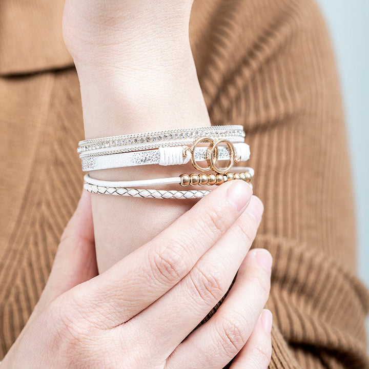 A close-up view of a leather bracelet with two interlocking rings at its center, representing the eternal bond between a granddaughter and a grandmother. The bracelet is accompanied by a greeting card and packaged in a gift box and bag. Material: Leather. Processing Techniques: Plating. Suitable for all ages."