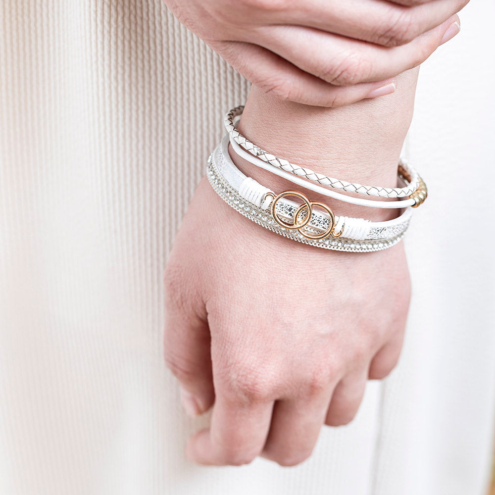 A close-up view of a leather bracelet with two interlocking rings at its center, representing the eternal bond between a granddaughter and a grandmother. The bracelet is accompanied by a greeting card and packaged in a gift box and bag. Material: Leather. Processing Techniques: Plating. Suitable for all ages."