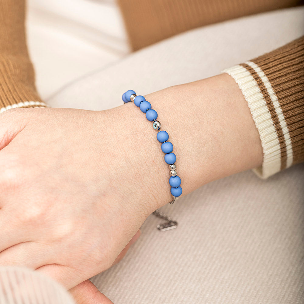 A titanium steel bracelet featuring an evil eye design, symbolizing protection from negativity and harm. Accompanied by a greeting card, gift box, and bag. Material: Titanium steel. Processing Techniques: Plating. Suitable for all ages.