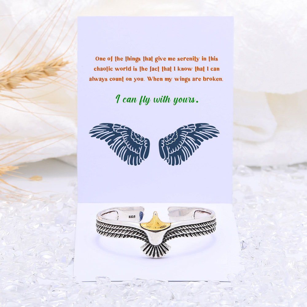 Stylish cuff bracelet with wing design, presented with a greeting card, gift box, and bag.